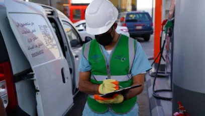 فني شركة الطرق الأخضر لخدمات المعايرة والمترولوجيا بجانب سيارات الفحص الميداني